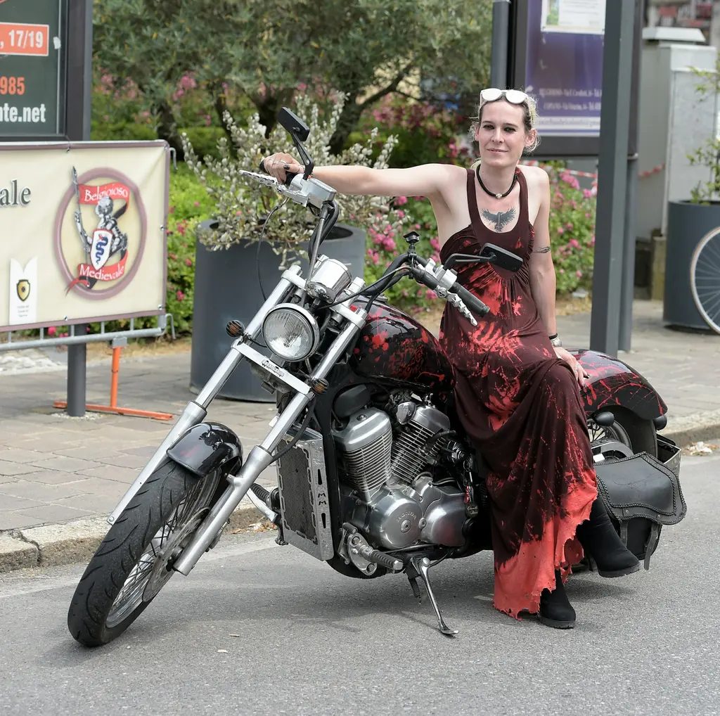 A woman in a dress sitting on a chopper