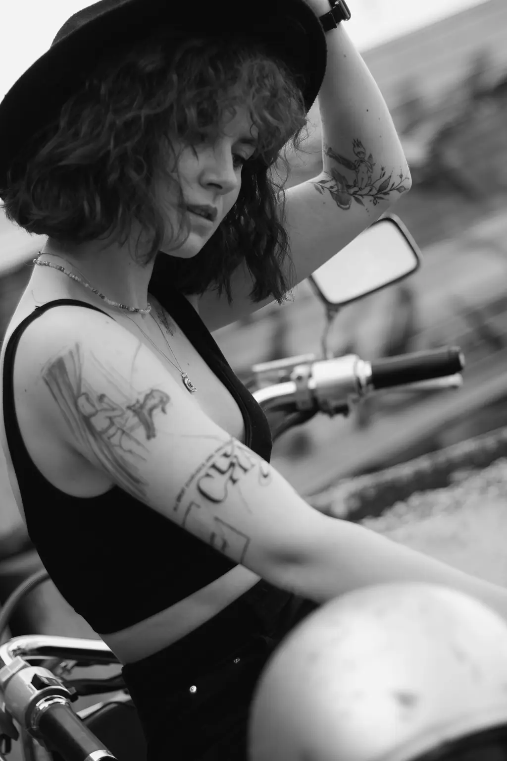 A woman with tattooed arms on her motorcycle