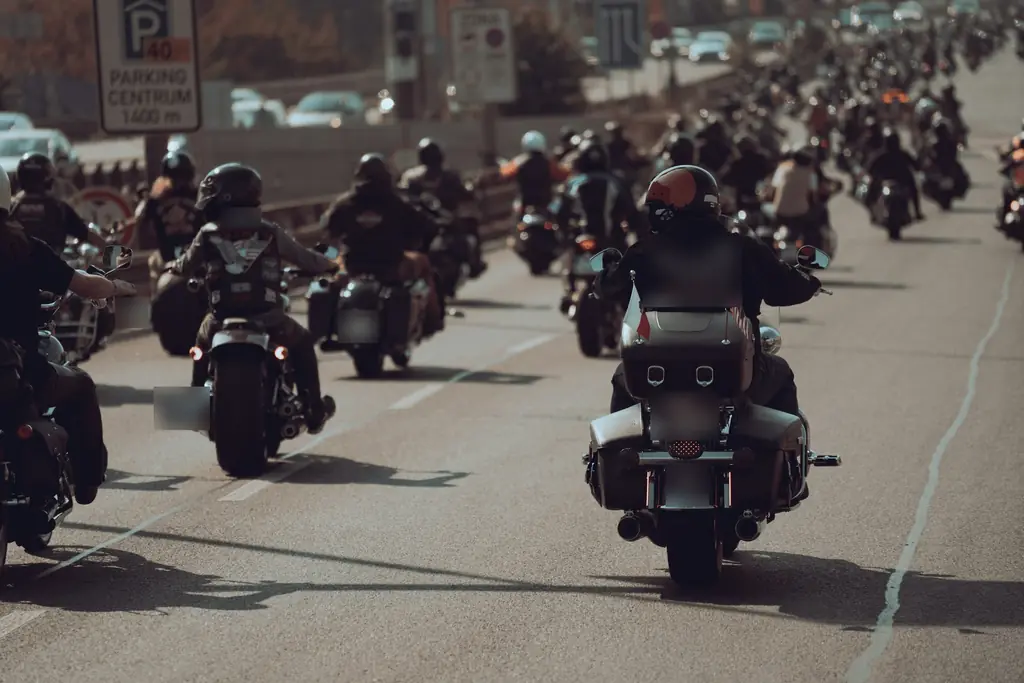 A pack of riders on cruisers and baggers rolling down a city street